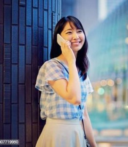 Young japanese woman is talking using her mobile phone
